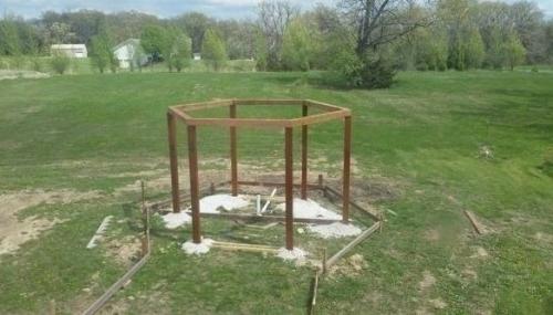 Беседка с качелями в виде инвалидных кресел с кострищем в середине. 02