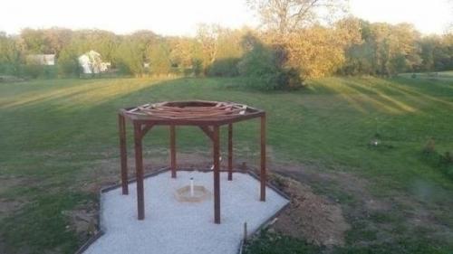 Беседка с качелями в виде инвалидных кресел с кострищем в середине. 03